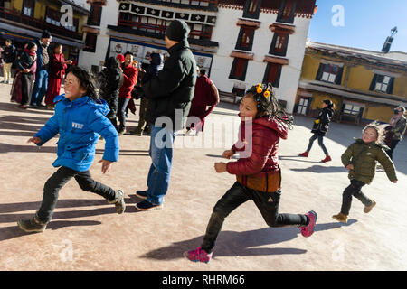 Playful Tibetan kids running in the courtyard of Potala Palace, Lhasa, Tibet Stock Photo