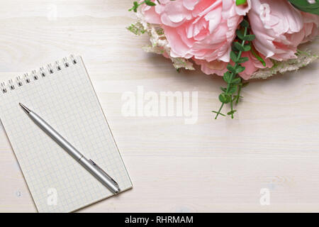 Flower with open blank note book and ink pen Stock Photo