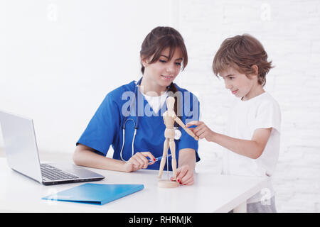 Doctor explain medicine to child using wooden doll Stock Photo