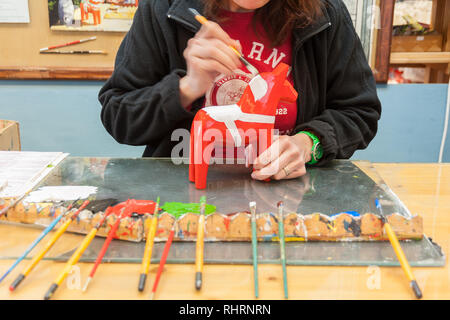 Mora, Sweden. 02/15/2017. Dala Horse factories of Nusnäs. In a workshop of carved Dalecarlian Horse. Employee is painting decoration on wooden horse. Stock Photo