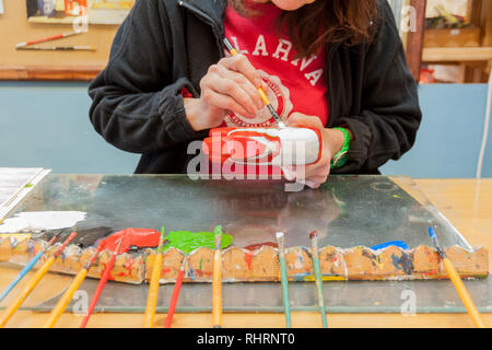 Mora, Sweden. 02/15/2017. Dala Horse factories of Nusnäs. In a workshop of carved Dalecarlian Horse. Employee is painting decoration on wooden horse. Stock Photo