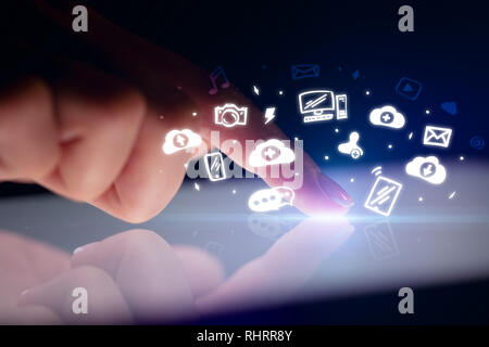 Finger touching tablet with white drawn application icons and dark background  Stock Photo