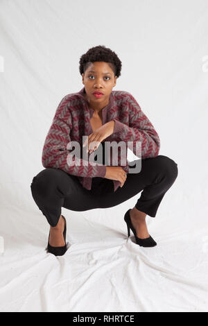 Lovely Black woman squatting thoughtfully Stock Photo - Alamy