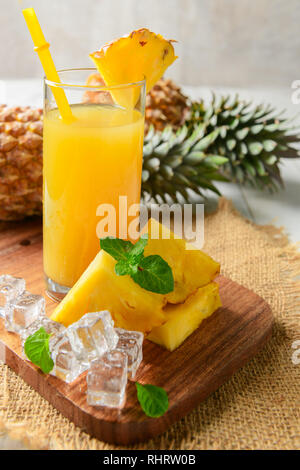 pineapple juice with slice pineapple and ice on wood background, summer drink concept Stock Photo