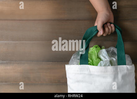 Hand girl holding canvas tote bag on wood background, save environmental and recycle concept Stock Photo