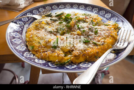 An omelette or frittata on a beautiful blue plate with natural light, ready for brunch Stock Photo