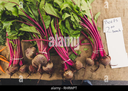 Fresh organic beets for sale at the Farmer's Market in Montrose, near Los Angeles, California displayed beautifully on a burlap table cloth. Stock Photo