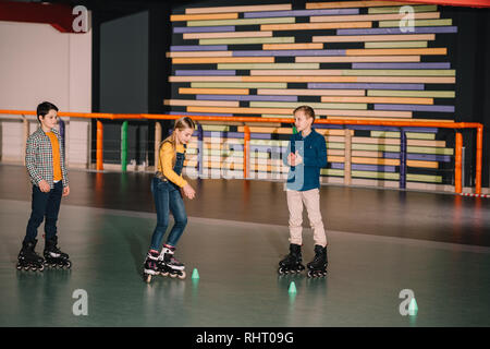 Preteen roller skaters practicing skating on rink together Stock Photo