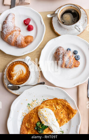 Breakfast. Croissants, coffee and many different dishes on the table in the restaurant. Frittata - italian omelet. Omelette with tomatoes, avocado Stock Photo