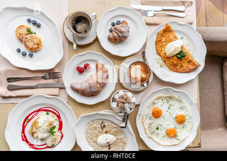 Breakfast. Croissants, coffee and many different dishes on the table in the restaurant. Frittata - italian omelet. Omelette with tomatoes, avocado Stock Photo