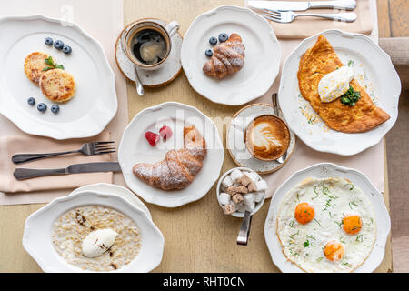 Breakfast. Croissants, coffee and many different dishes on the table in the restaurant. Frittata - italian omelet. Omelette with tomatoes, avocado Stock Photo