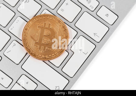 Bitcoin souvenir coin on a white keyboard next to the enter key Stock Photo