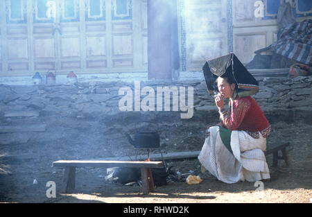 The mother of the bride smoking at her daughter's wedding in a small village in the mountains above Weixi in Yunnan province, China. The marriage of h Stock Photo