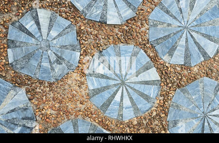 Ornamental-style of marble pieces, put together with concrete in round shapes, surrounded by gravel pathway flooring. Self-made style seen in Asia Stock Photo