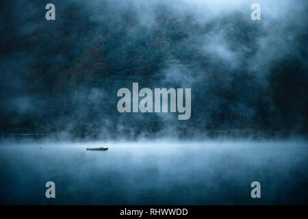 boat on Lake Shōji in morning mist Stock Photo