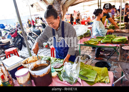 Woman making traditional read bean pancakes, Friday morning market, Chiang Mai Stock Photo