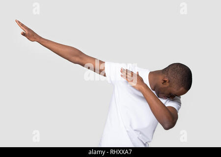Happy black man making dab gesture on blank studio background  Stock Photo
