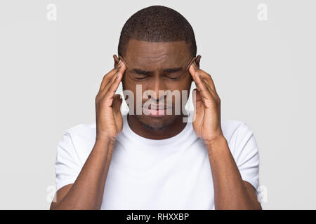 Stressed young african american man feeling pain having terrible headache Stock Photo