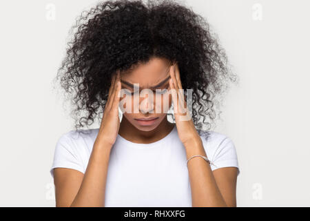 Upset stressed black woman massaging temples feeling pain terrible migraine Stock Photo