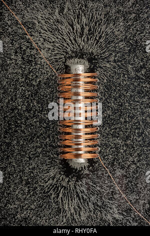 Faint electromagnetic fields causing magnetism when high current and voltage passed through windings of copper wire with soft iron core Stock Photo