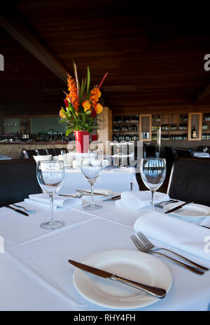 Table setting with flowers and bar in background Stock Photo
