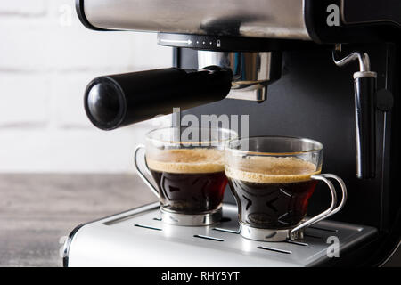 Fresh coffee in espresso coffee machine on wooden table Stock Photo