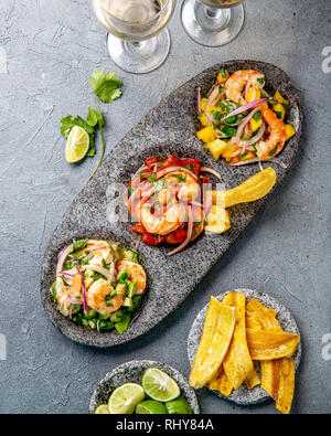 CEVICHE. Three colorful shrimps ceviche with mango, avocado and tomatoes. Latin American Mexican Peruvian Ecuadorian food. Served with white wine and Stock Photo