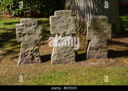 Three crosses of stone in a cemetery Stock Photo