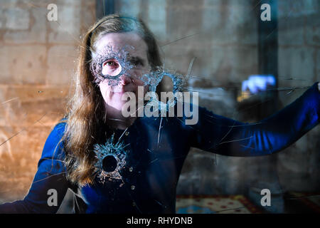 Salisbury Cathedral Archivist Emily Naish looks through holes in reinforced glass that were left after a hammer attack on the casing housing an original Magna Carta inside the medieval Chapter House at the Cathedral, which is now reinstalled for the viewing public. Stock Photo