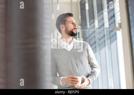Thoughtful businessman having coffee in office Stock Photo