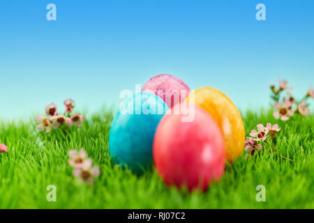 Four brightly painted easter eggs as easter background decoration on a green meadow Stock Photo