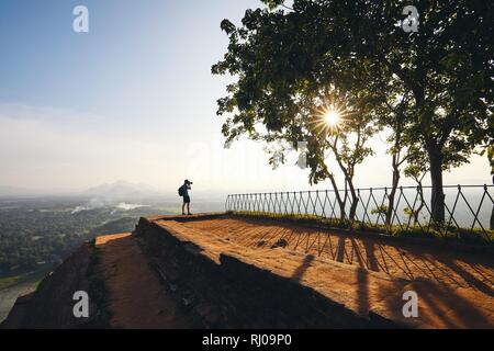 Silhouette of the photographer on the top of Sigiriya rock at the sunset, Sri Lanka. Stock Photo