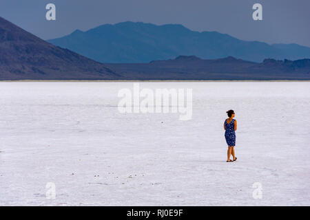 Bonneville Salt Flats, Utah, United States - August 15, 2018: Woman walking alone on the Bonneville Salt Flats in Utah. Stock Photo