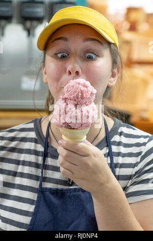 High school girl scooping up ice cream for a customer Stock Photo