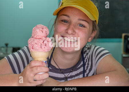 High school girl scooping up ice cream for a customer Stock Photo