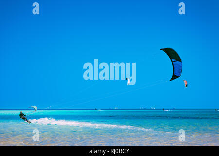 Egypt, Hurghada - 30 November, 2017: The kiter gliding over the Red sea surface. The active leisure. Picturesque marine scenery. The popular tourist water attraction. The outdoor sport activity. Stock Photo