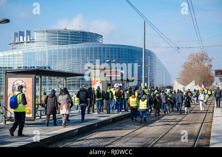 STRASBOURG, FRANCE - FEB 02, 2018: People demonstrating walking toward European Parliament during protest of Gilets Jaunes Yellow Vest manifestation anti-government demonstrations
