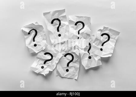 Border of crumpled question marks on cards over a white background with copy space in a conceptual image Stock Photo