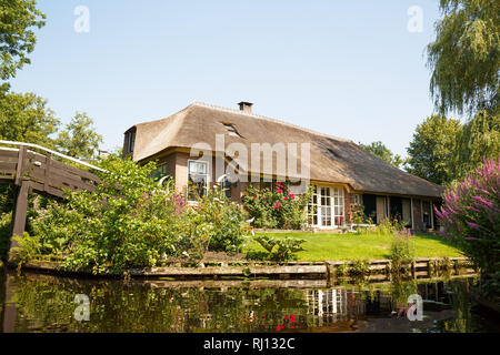 The thatched roof house with beatiful garden in fairytale village Giethoorn in The Netherlands. Stock Photo