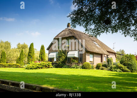 The thatched roof house with beatiful garden in fairytale village Giethoorn in The Netherlands. Stock Photo