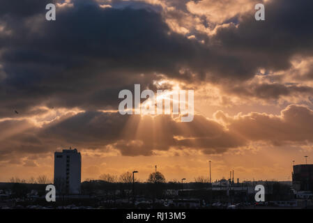 Dramatic sky with rays of sun over city Stock Photo