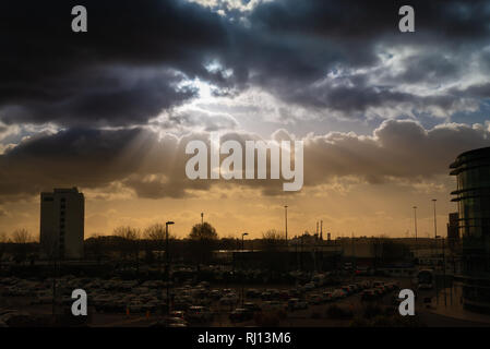 Dramatic sky with rays of sun over city Stock Photo