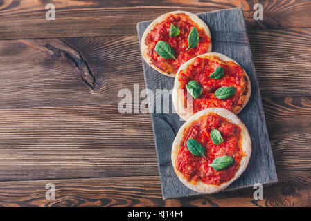 Mini Margherita pizzas with red cheese on the wooden board Stock Photo