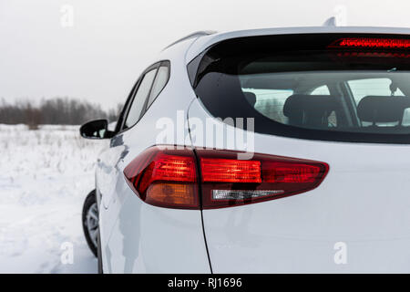 White modern car with lit brake lights. Rear view. Stock Photo