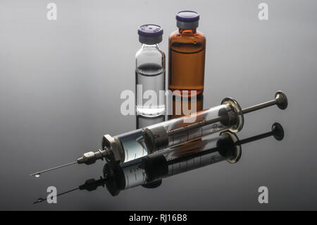 Syringe vintage next to vials, conceptual image Stock Photo