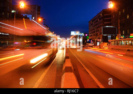 Oiled highway lights in motion. Evening dark city. Cars go on the road. Stock Photo