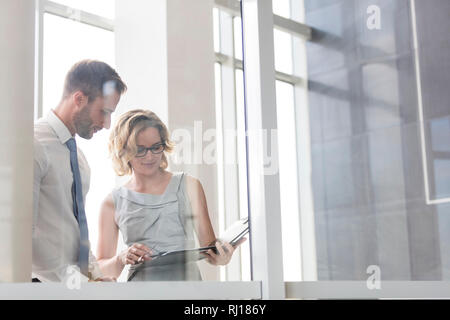Businesswoman discussing with businessman over document at office Stock Photo