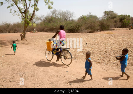 Samba village, Yako Province, Burkina Faso; Salamata Zoundi, 27, goes to fetch water from the nearby pump with her triplets, Christelle,  Christine and Christophe, aged 2 Stock Photo