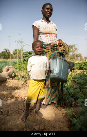 Samba village, Yako Province, Burkina Faso:  Collette Guiguemde, 26, with her four-year-old daughter Eulalie Zondi in the market garden. Stock Photo