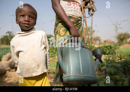 Samba village, Yako Province, Burkina Faso:  Collette Guiguemde, 26, with her four-year-old daughter Eulalie Zondi in the market garden. Stock Photo